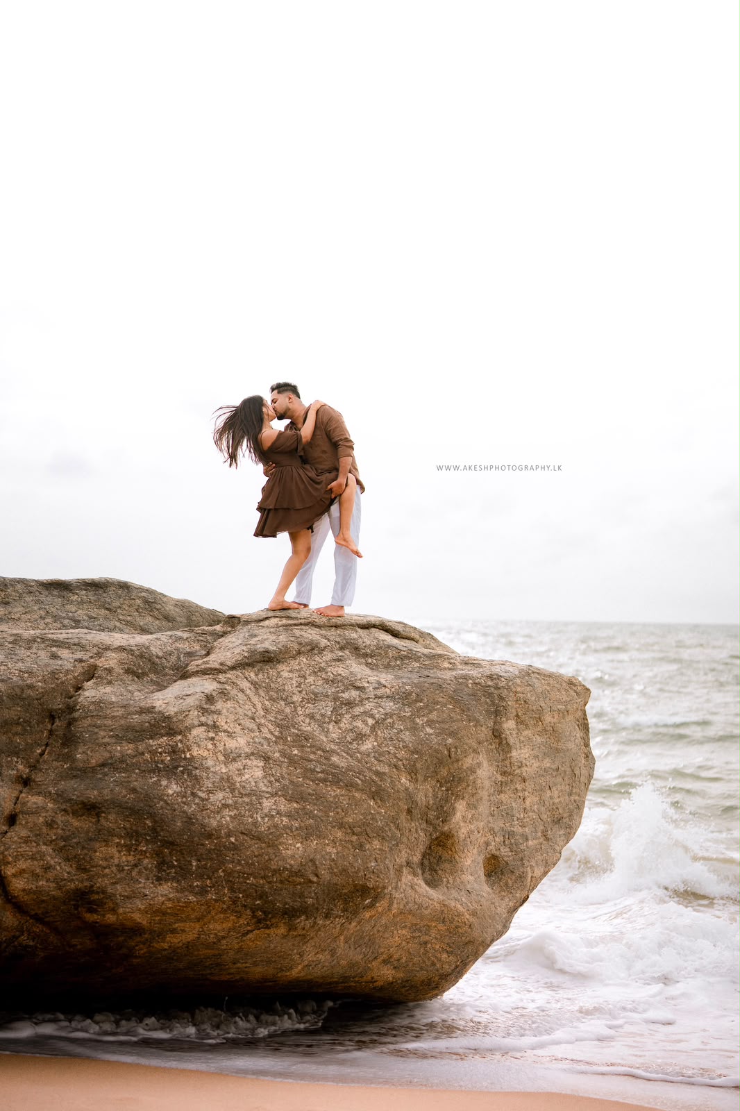 Couple standing on a seaside rock together