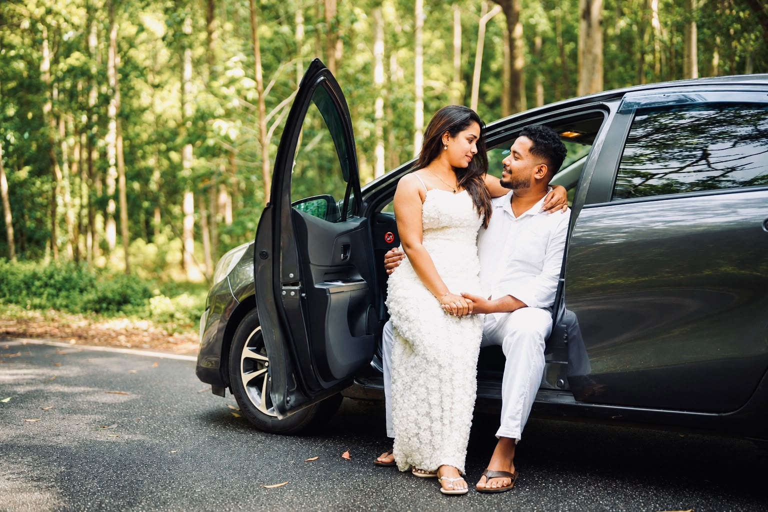 Poorni and Vimukthi posing beside a car